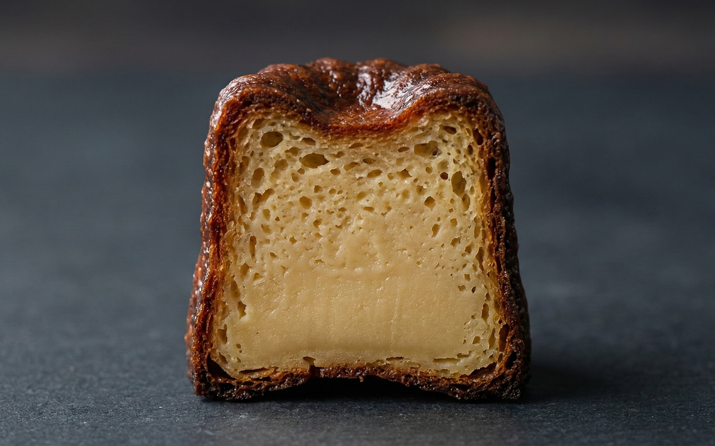 米粉カヌレの断面：上部にわずかな気泡があり、下に向かって濃密なカスタードのような見た目