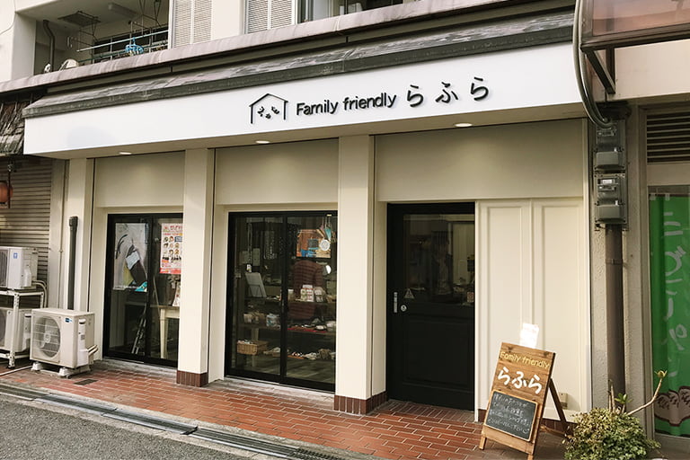 店外の写真。ホワイトやベージュ、茶色を基調とした色合いにらふらのロゴが映えるシンプルでナチュラルな雰囲気の外観です。