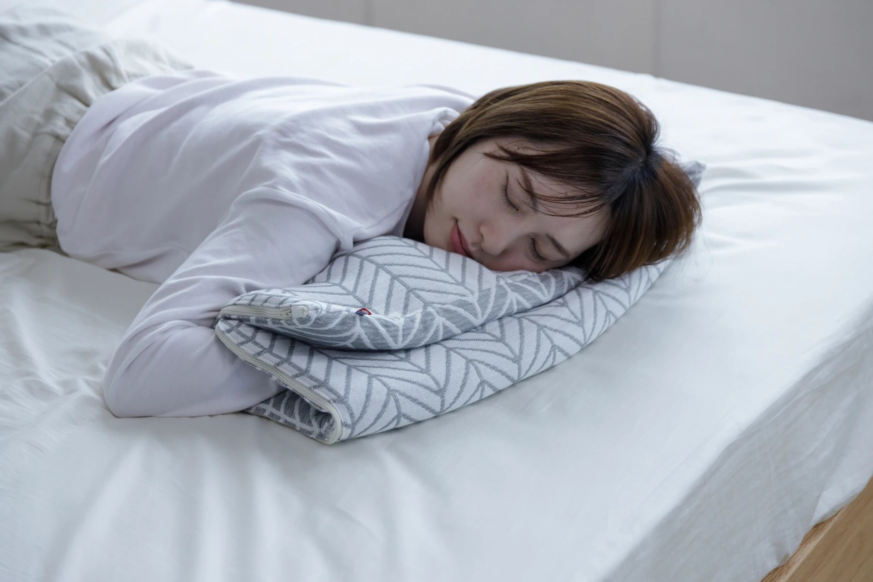 今治3重ガーゼ枕を折り重ねて横向きに眠る女性